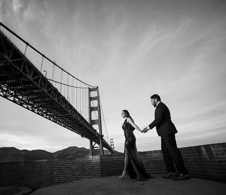 Engaged Indian couple walk under the Golden Gate Bridge
