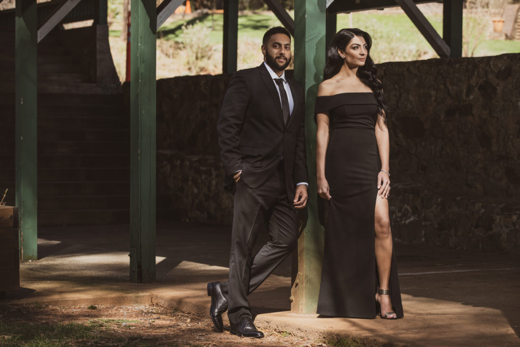 Couple dress in black for their engagement shoot in rustic barn